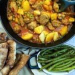 A dish of chicken aloo matar with Indian green beans in the foreground.