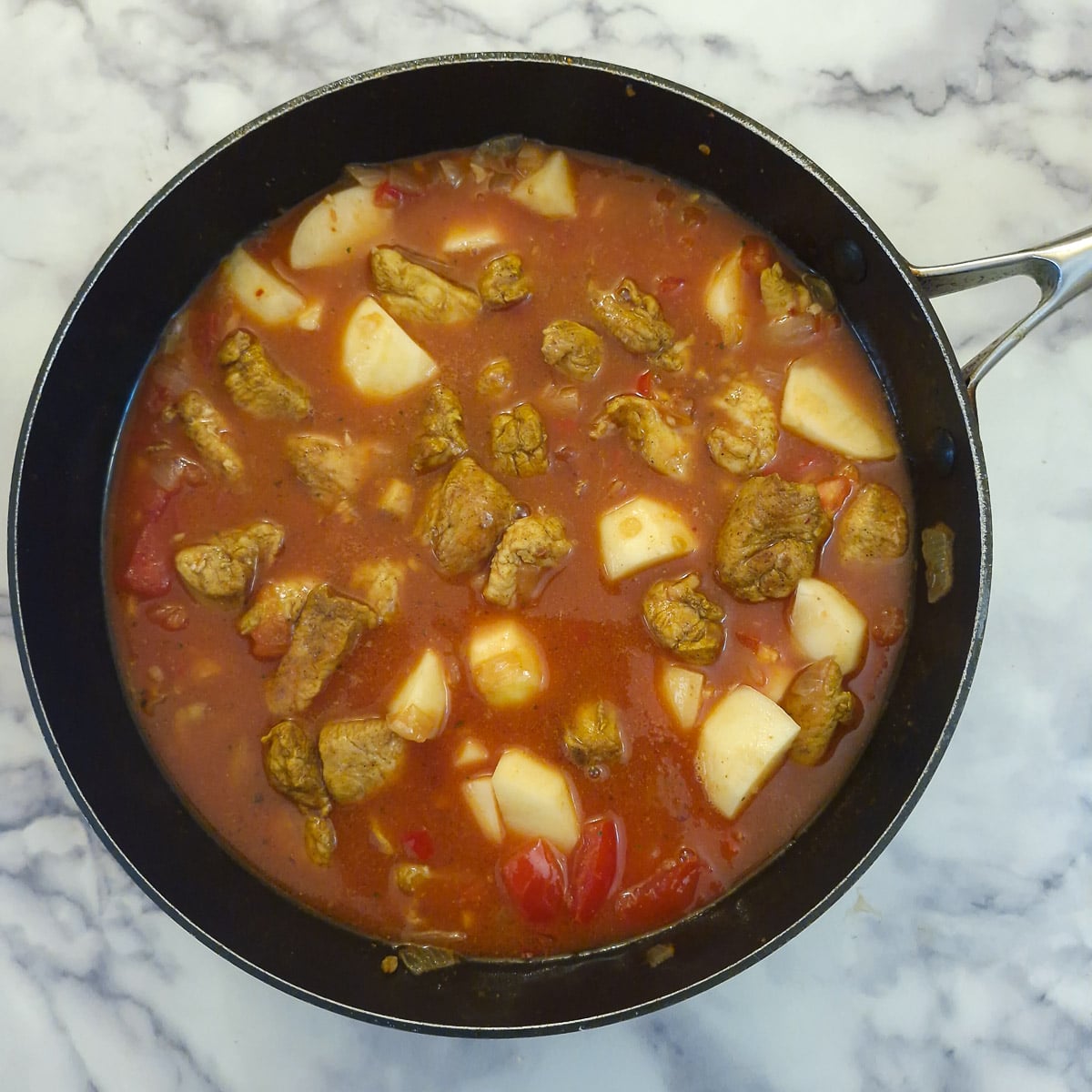 Step 6, stock, passata, chicken and potatoes added to the pan.