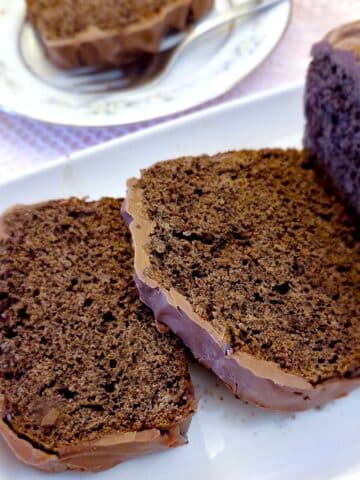 Slices of chocolate loaf cake with a covering of chocolate.