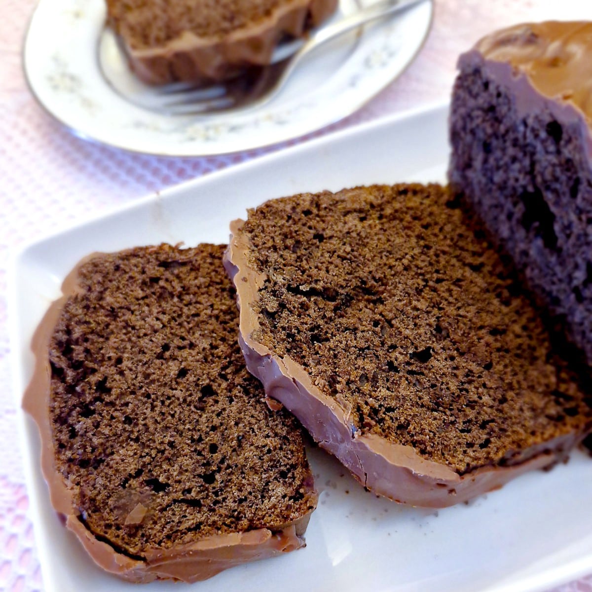 Slices of chocolate loaf cake with a covering of chocolate.