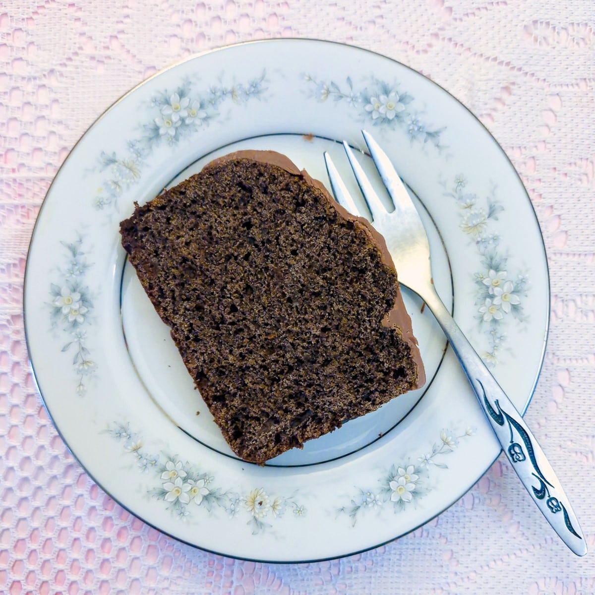 A slice of chocolate ice cream cake on a blue patterned plate with a cake fork.