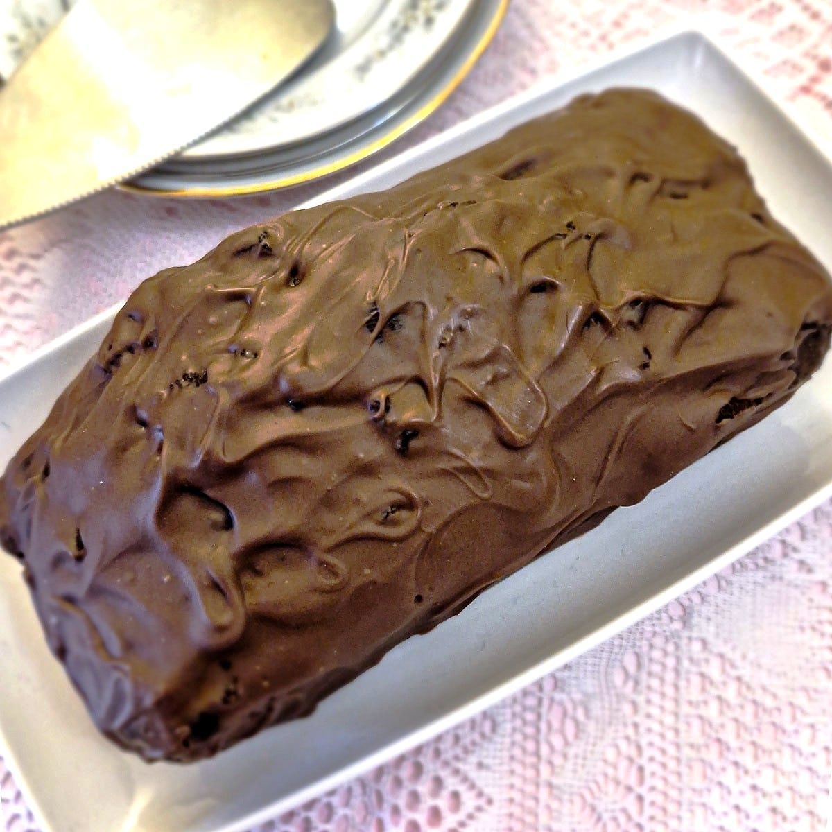 Overhead view of a chocolate ice cream loaf cake smothered in melted chocolate.