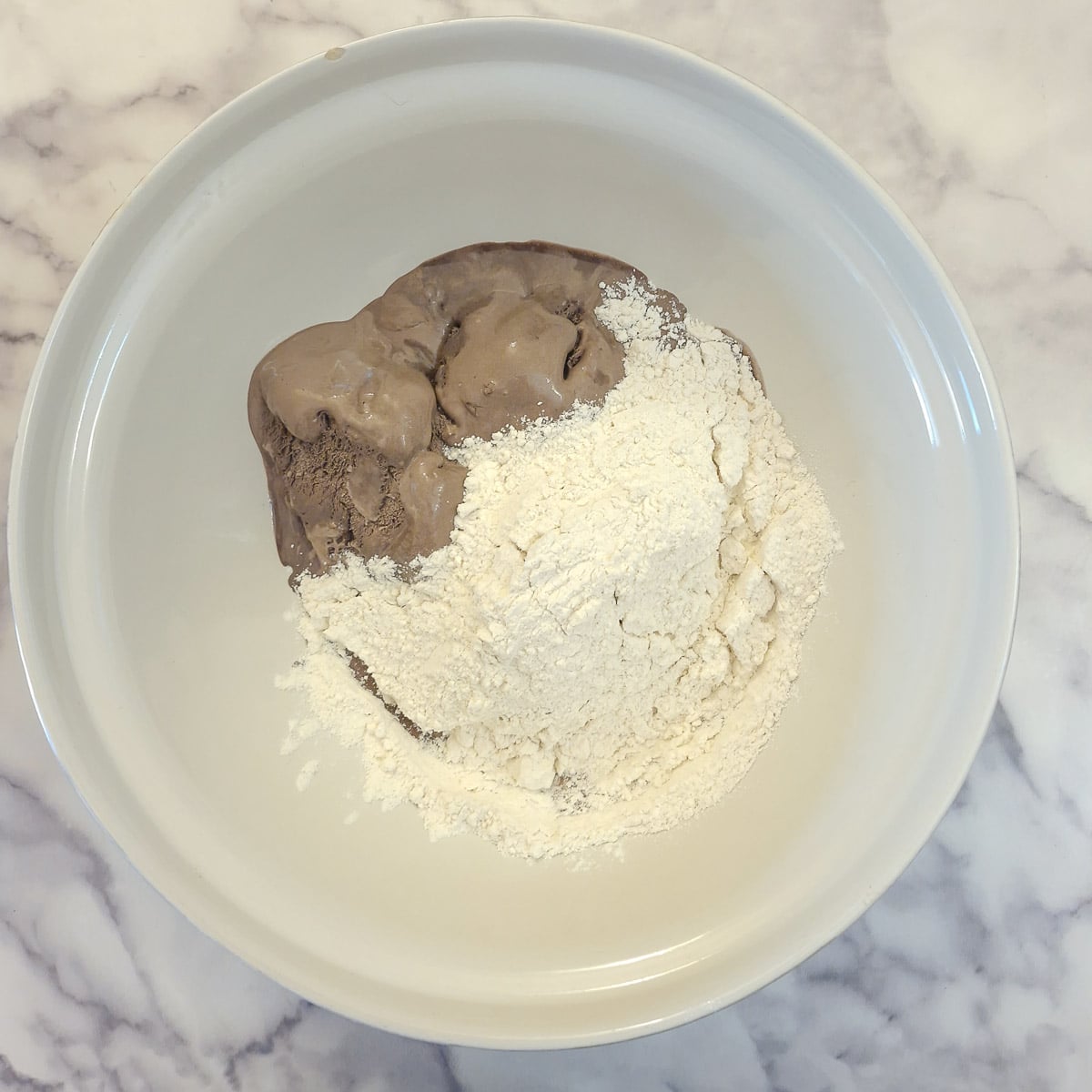 Step 1, place melted chocolate ice cream and self raising flour in a mixing bow.