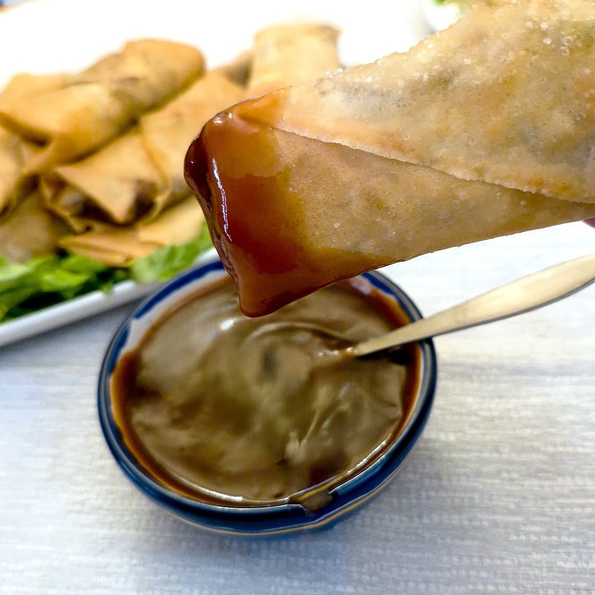 A crispy prawn spring roll that has been dipped in dipping sauce.