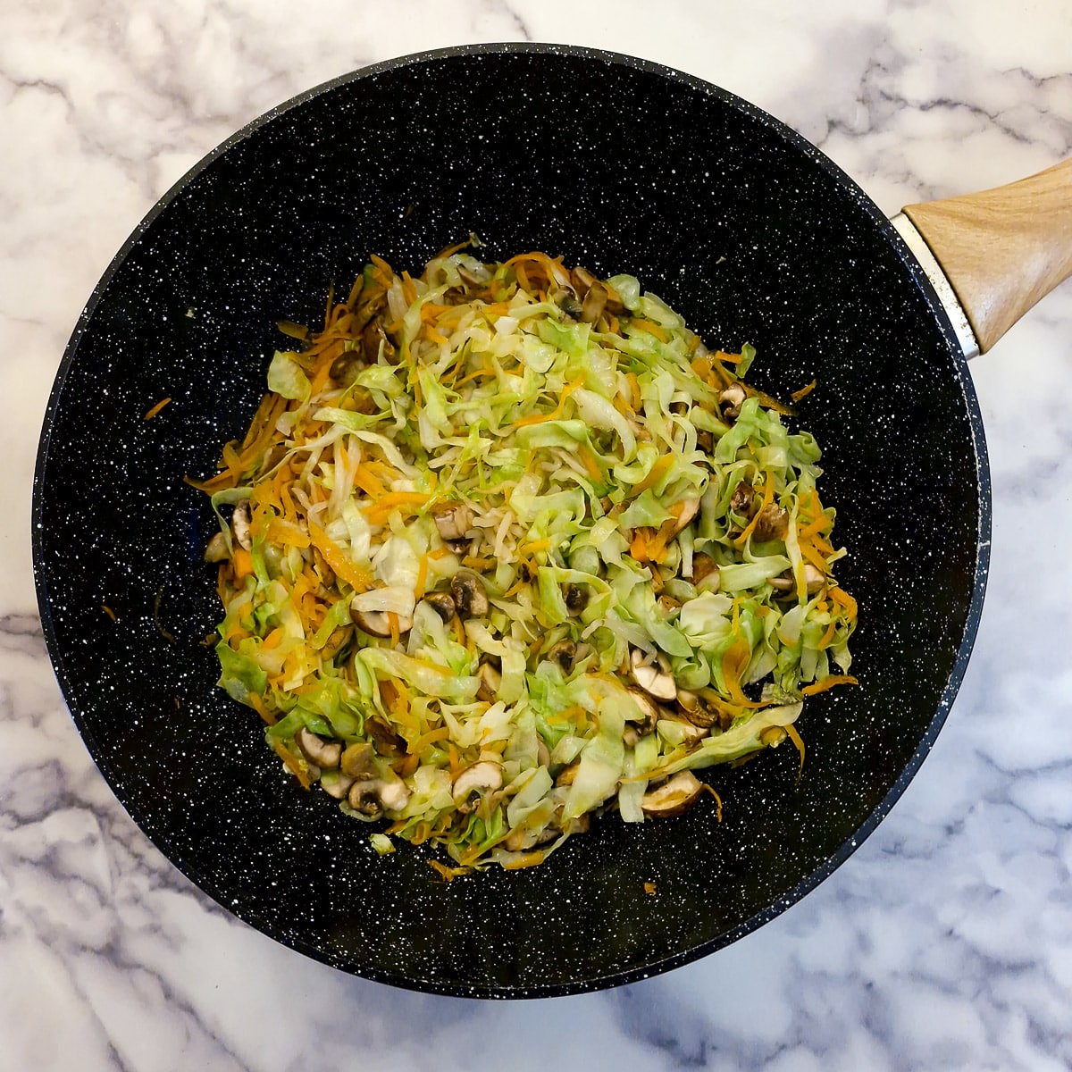 Step 1, carrots, cabbage, mushrooms and bean sprouts in a frying pan.