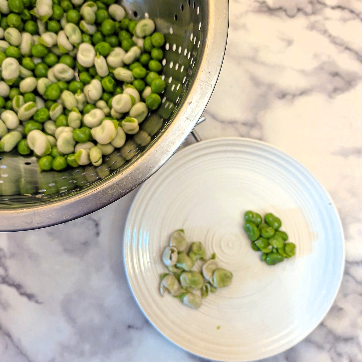 Outer skin being removed from the broad beans.