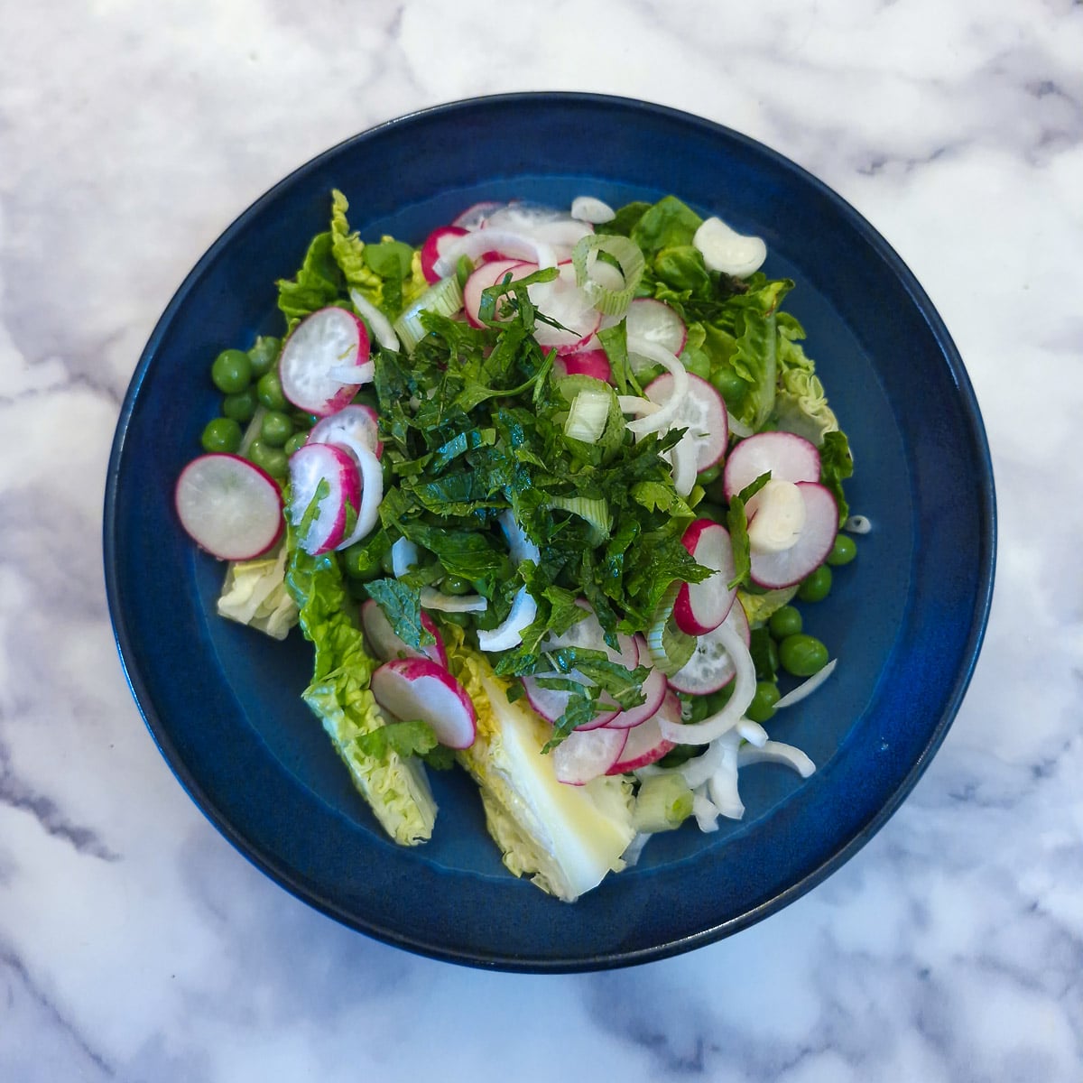 Salad ingredients in a blue bowl.