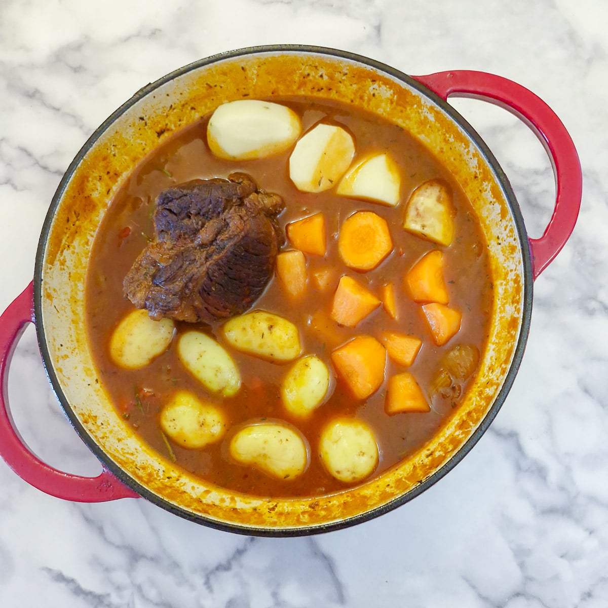 Step 4, the brisket has been cooking for 1.5 hous and the potatoes and carrots have been added to the pan.