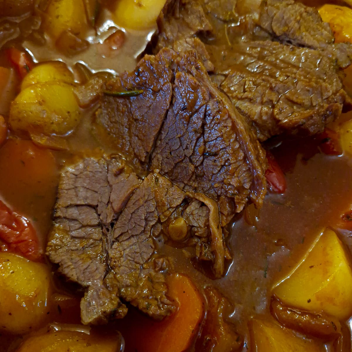 Step 5, close up of fully cooked brisket, sliced on top of the cooked vegetables.