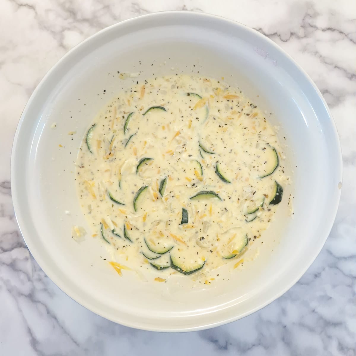 The softened vegetables and grated cheese added to the quiche batter.