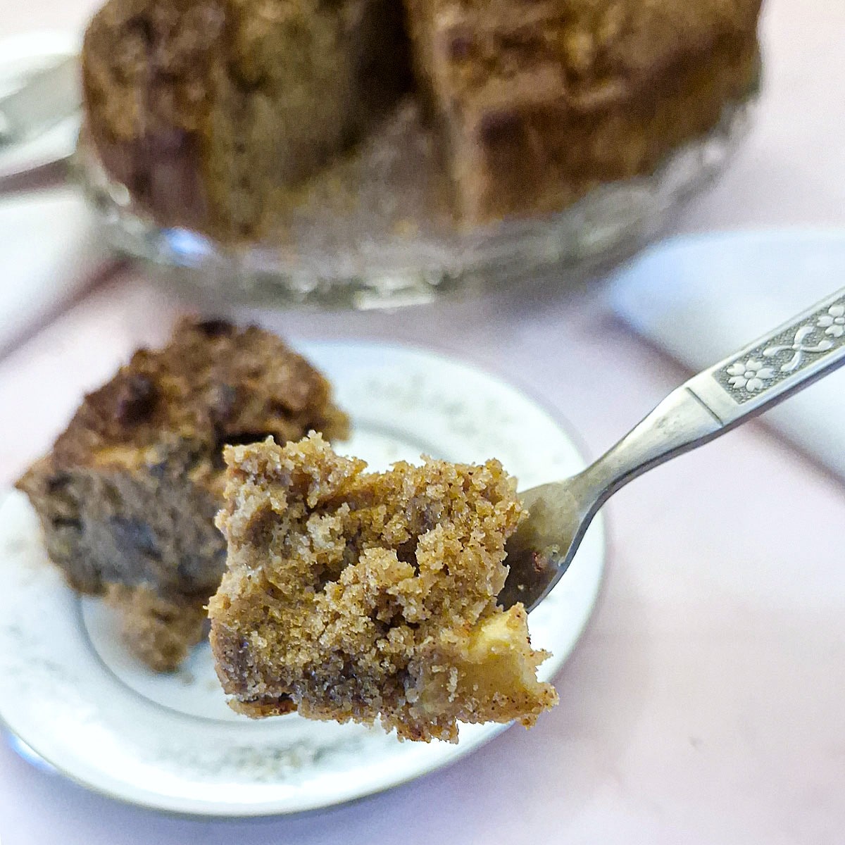 A cake fork holding a mouthful of apple and chestnut cake.