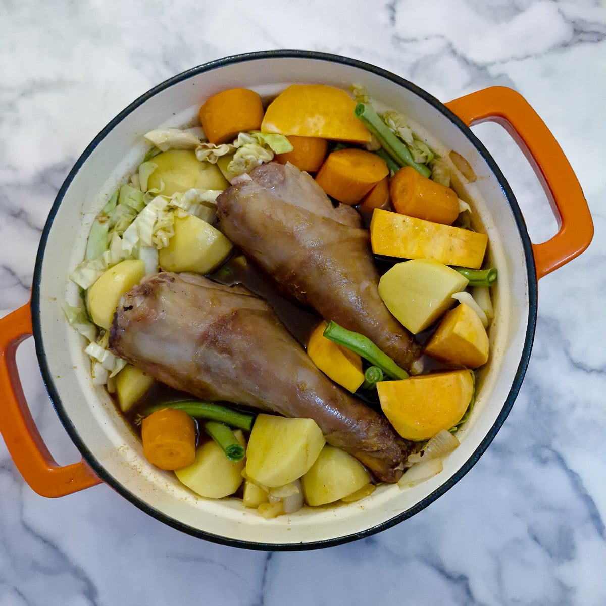 Step 5, lamb shanks nestled into the vegetables and stock.