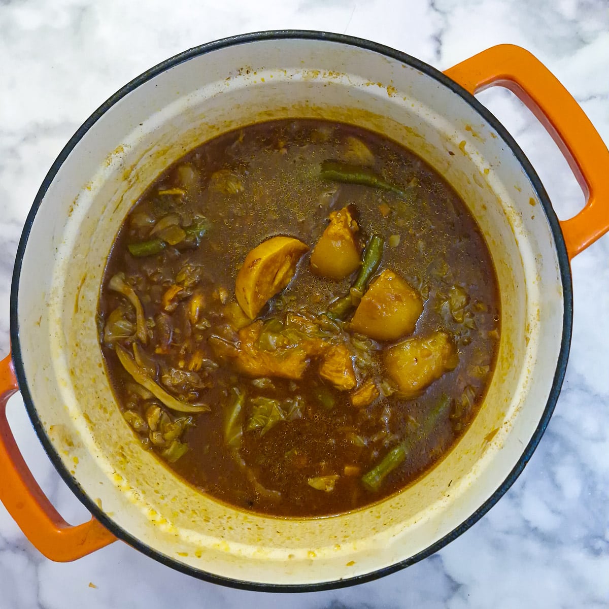 Step 7, The lamb and most of the vegetables have been removed from the pan, leaving only the gravy and a few vegetables.