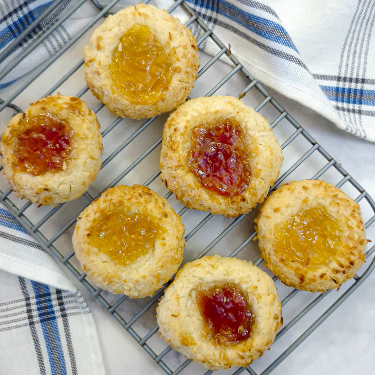 6 jam and coconut cookies on a wire cooling rack.