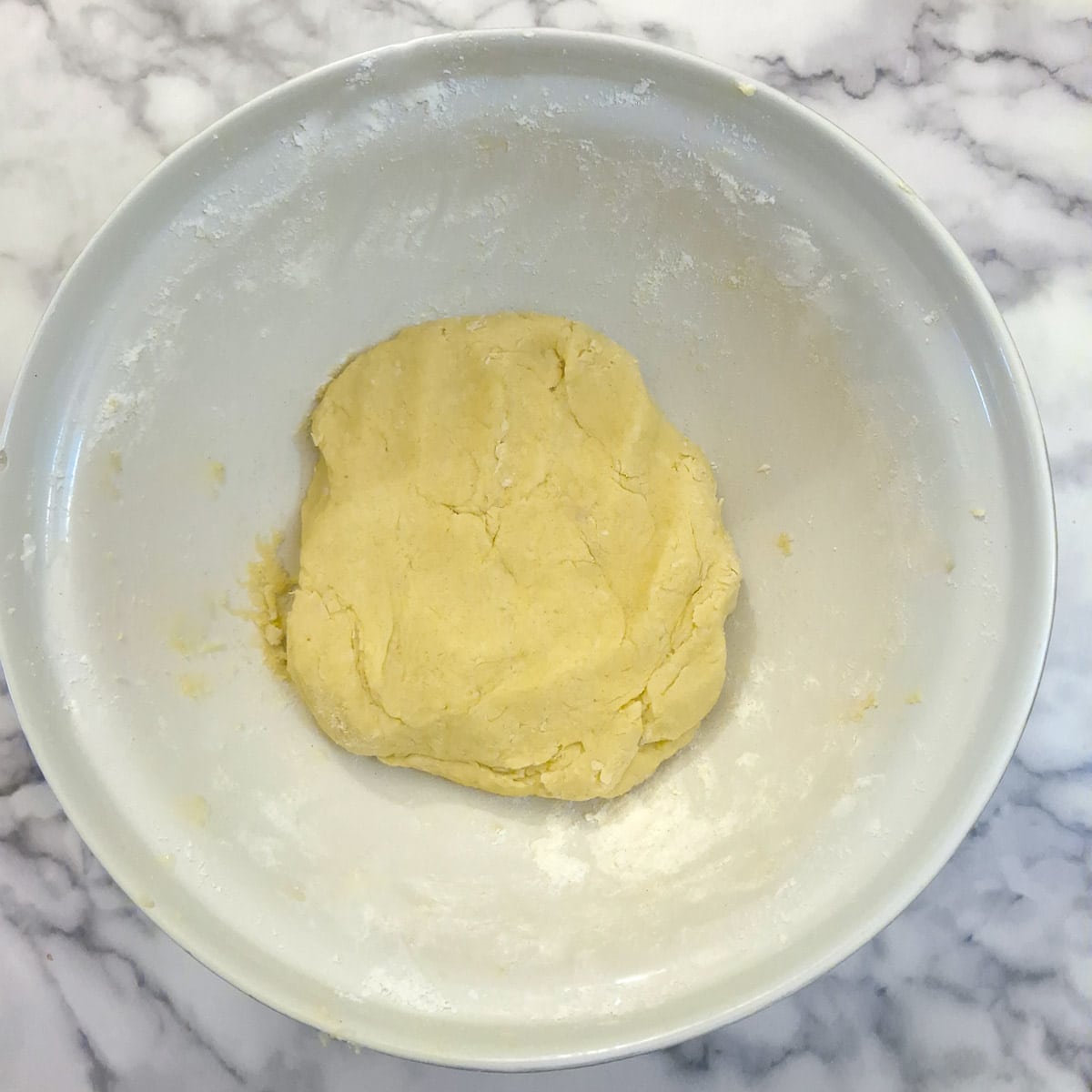 Step 3, add flour and coconut and mix to form a smooth ball of dough.