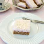 A sqiuare piece of coconut marshmallow wee-bix slice on a whte plate.
