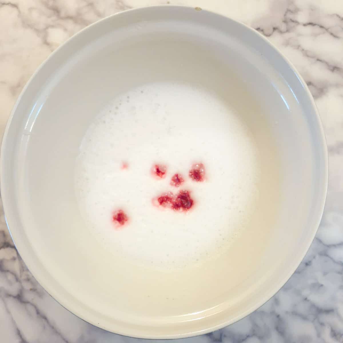Sugar mixture whisked until frothy, with a few drops of red food colouring on top.