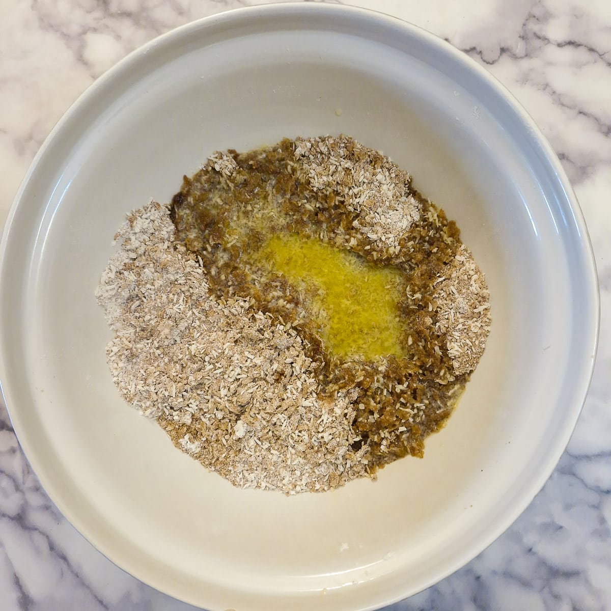 Melted butter poured over the dry ingredienets in a mixing bowl.
