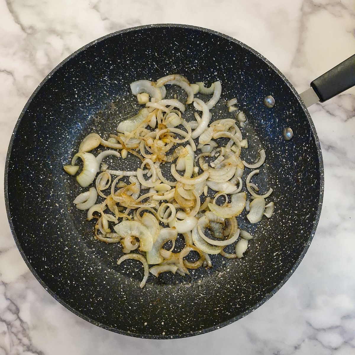 Onions browning in a frying pan.