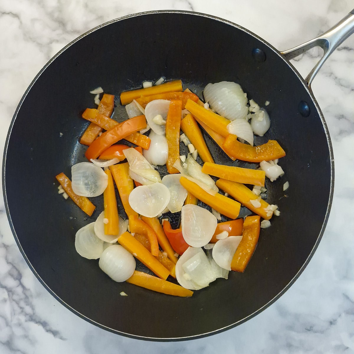 Step 2, onions, carrots and red pepper softening in a frying pan.