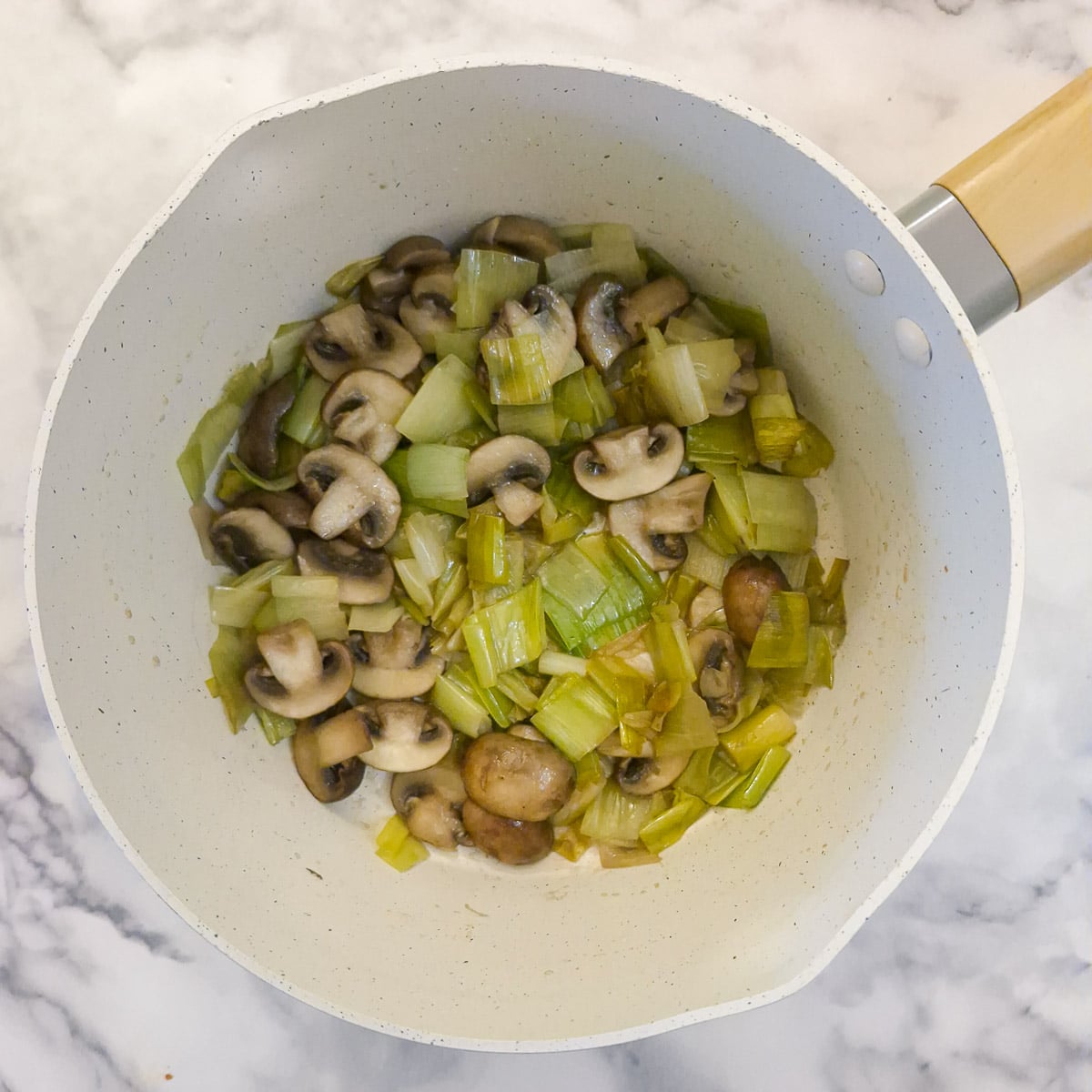 Mushrooms softening with the leeks.