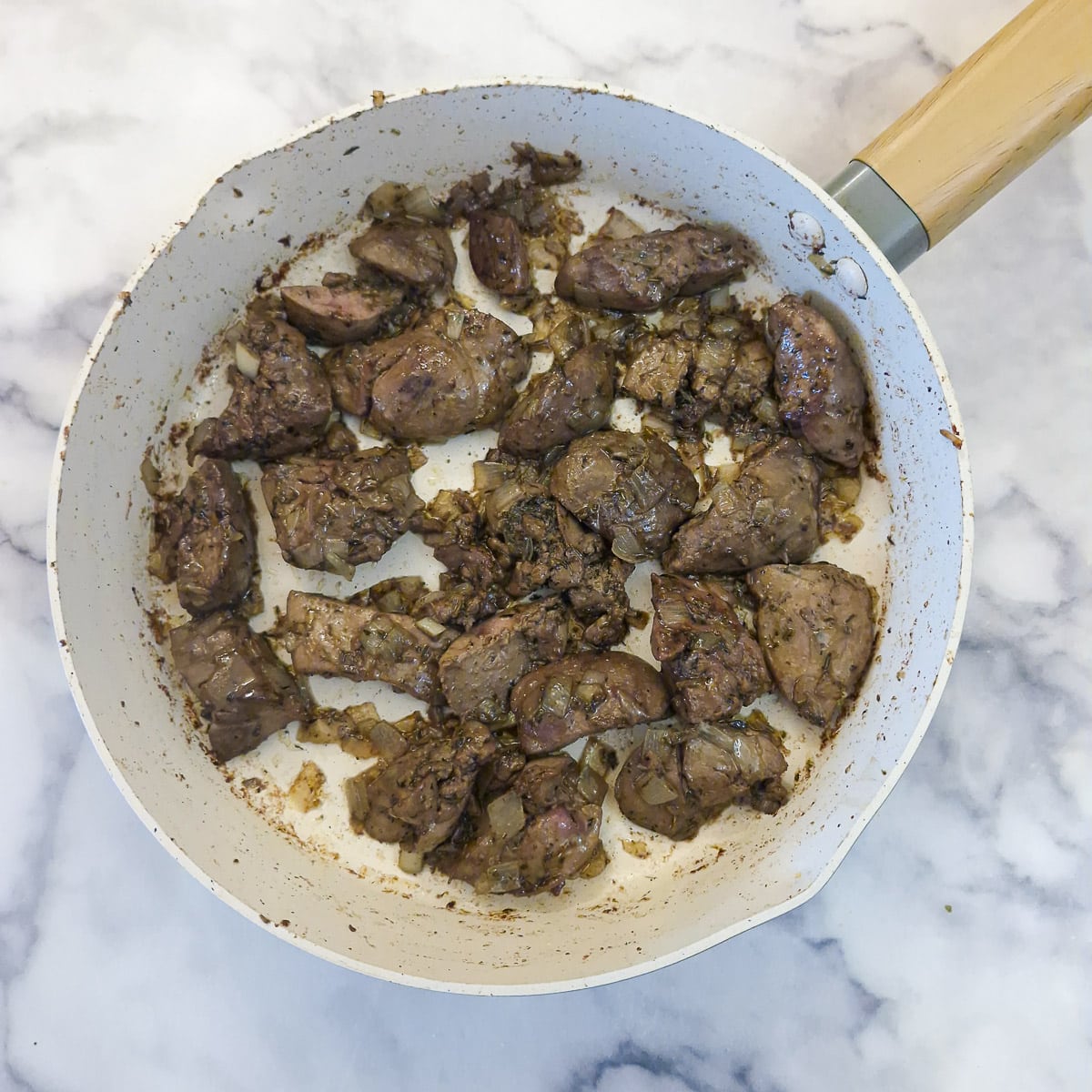 Pieces of duck liver browning with the shallots.