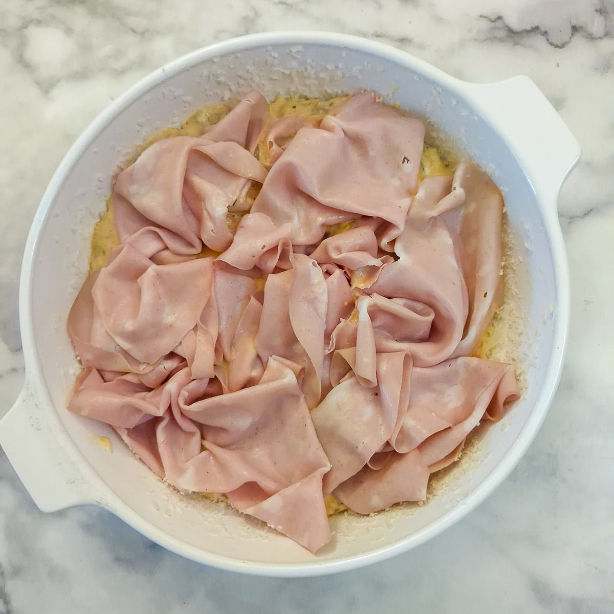 Mortadella scrunced up and arranged in the baking dish.