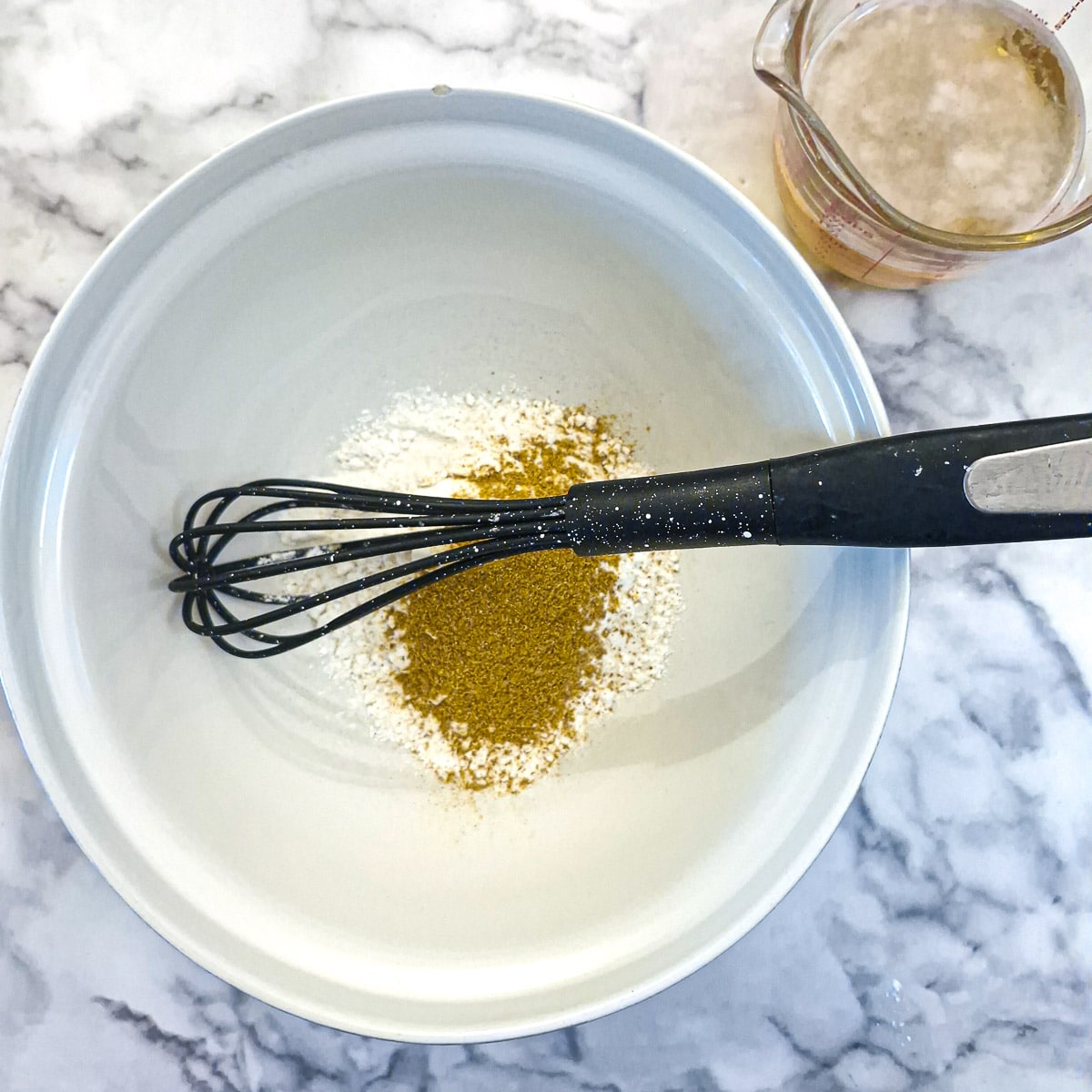 Step 2, flour and spices being combined in a mixing bowl.