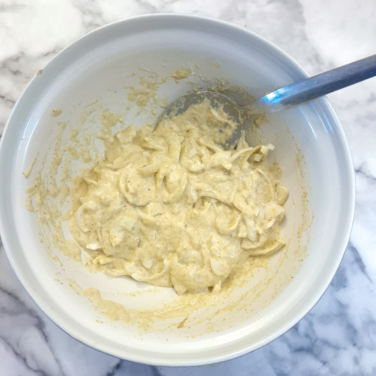 Step 5, sliced onions combined with batter in a mixing bowl.