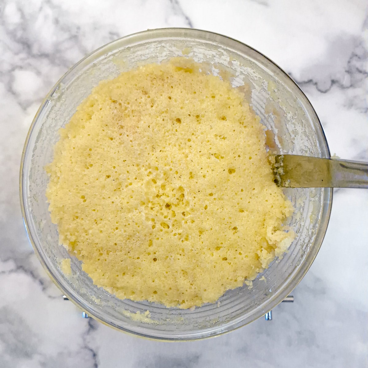 A knikfe being used to loosen the edges of the sponge pudding before it is tipped onto a serving plate.