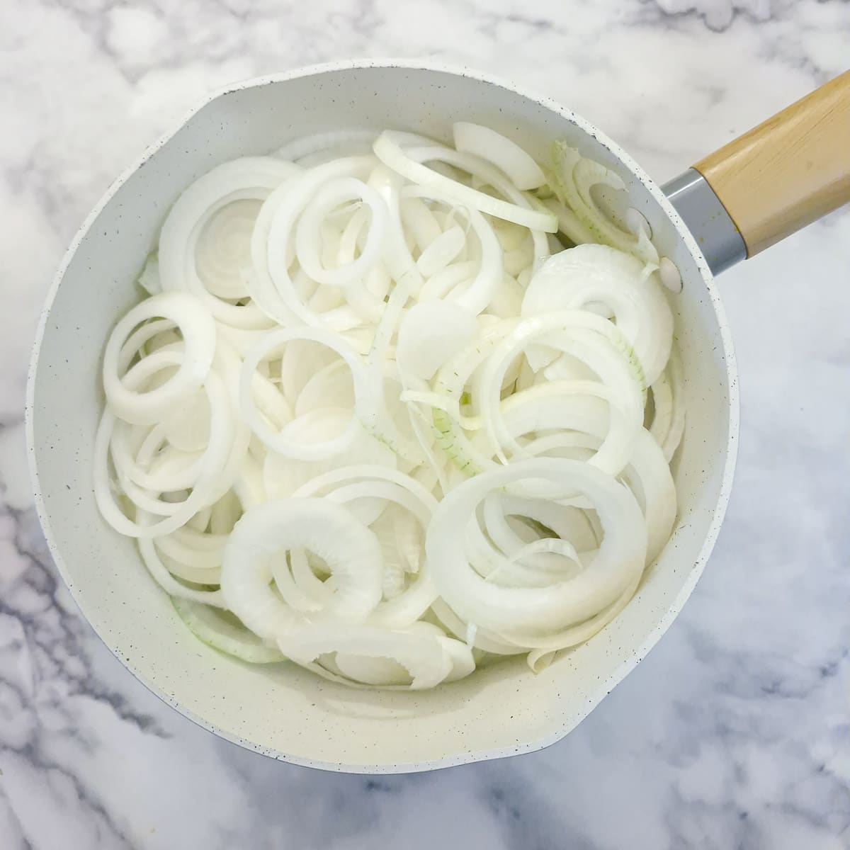 Step 1, sliced onions placed in a large saucepan.
