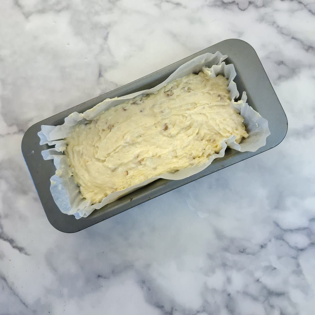 Step 5, cake batter transferred into a lined loaf tin.