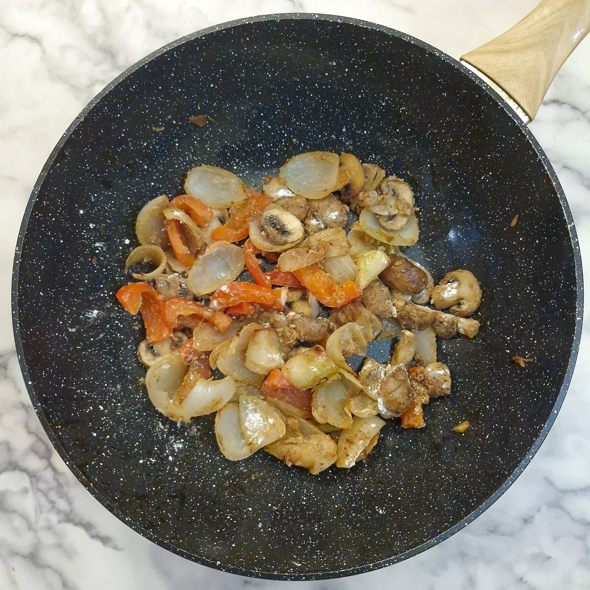 Cornflour stirred into the vegetables in a wok.