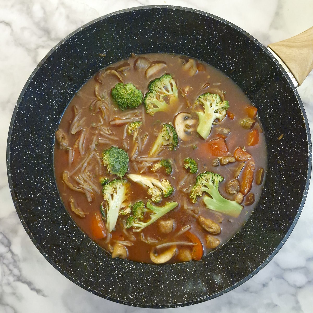 Sauce, broccoli and bean sprouts adde to the wok.
