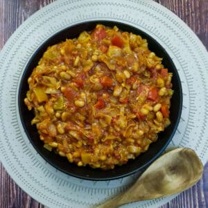 A black serving dish filled with spicy chakalaka.