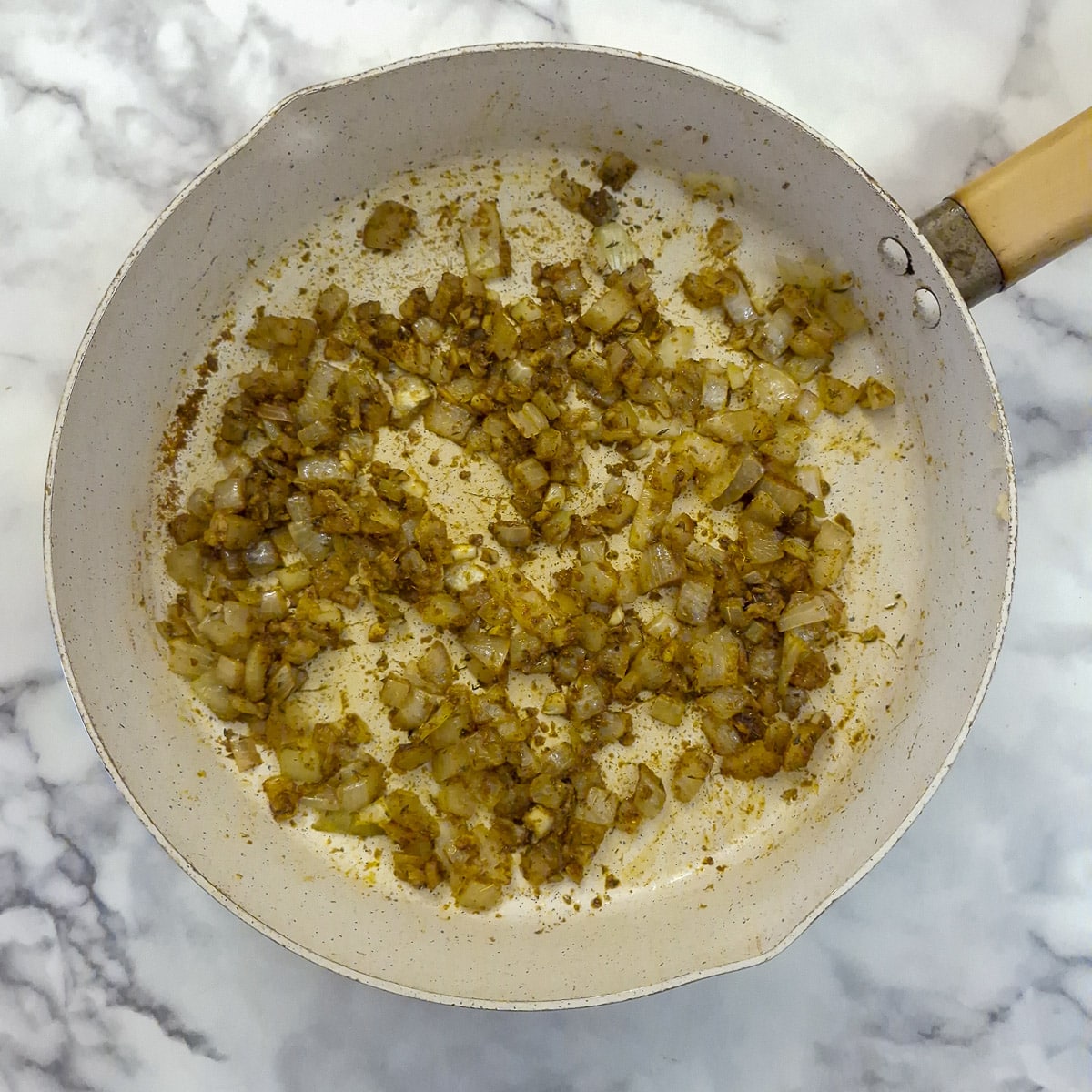 Step 2, spices mixed with fried onions in a pan.