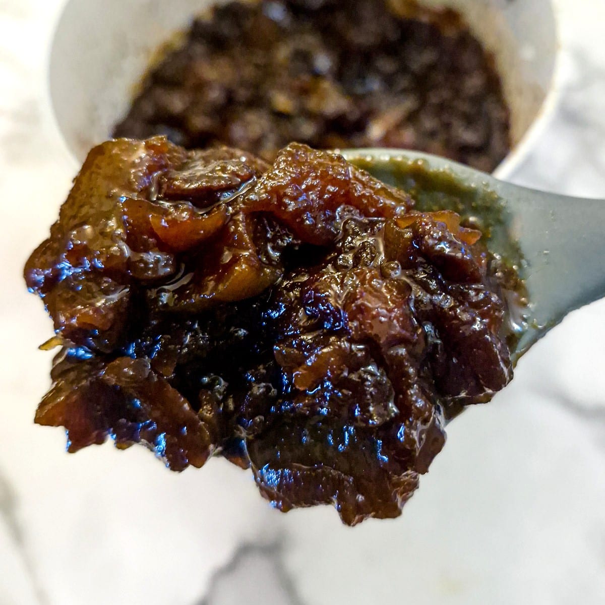 Close up of a spoonful of marrow and apple chutney.