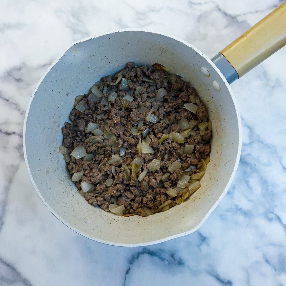 Step 2, beef mince being browned with onions in a saucepan.