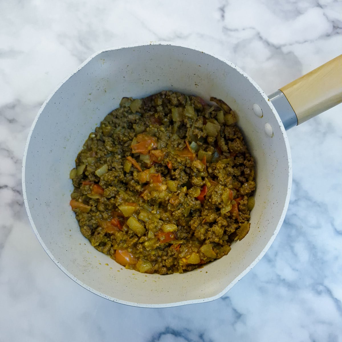 Step 4, diced tomatoes softening with the mince and onions.