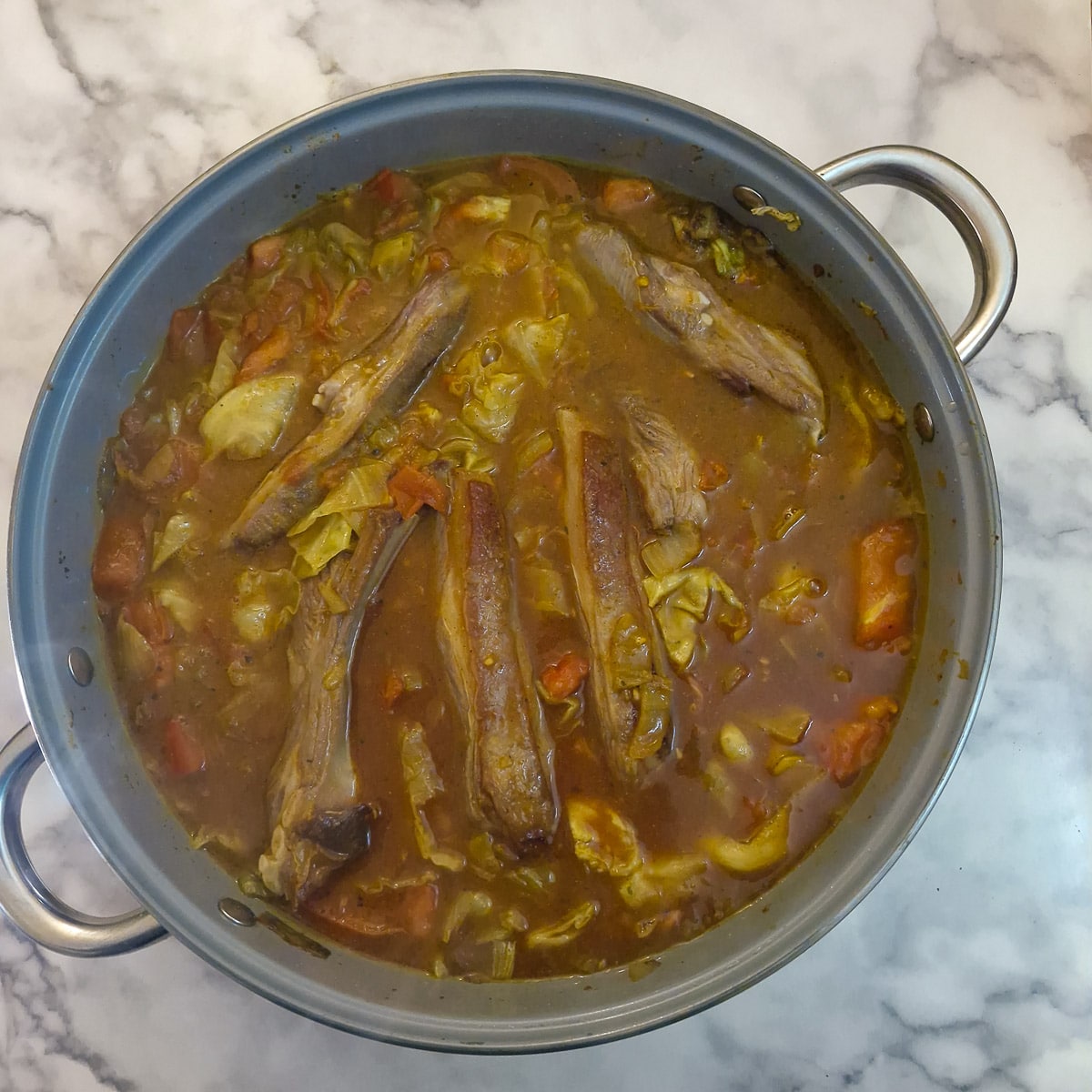 Step 7, lamb ribs returned to the pan and covered in seasoned stock.