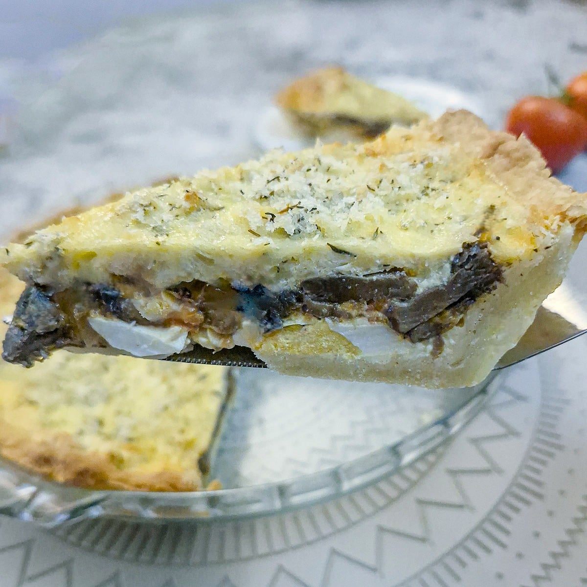A slice of egg and tomato quiche on a cake lifter.