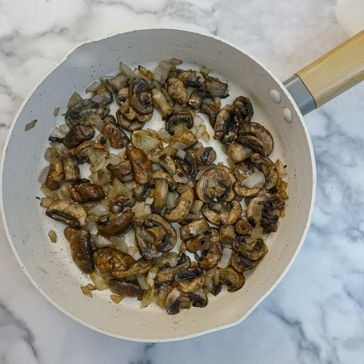 Step 4, mushrooms softening in a frying pan.