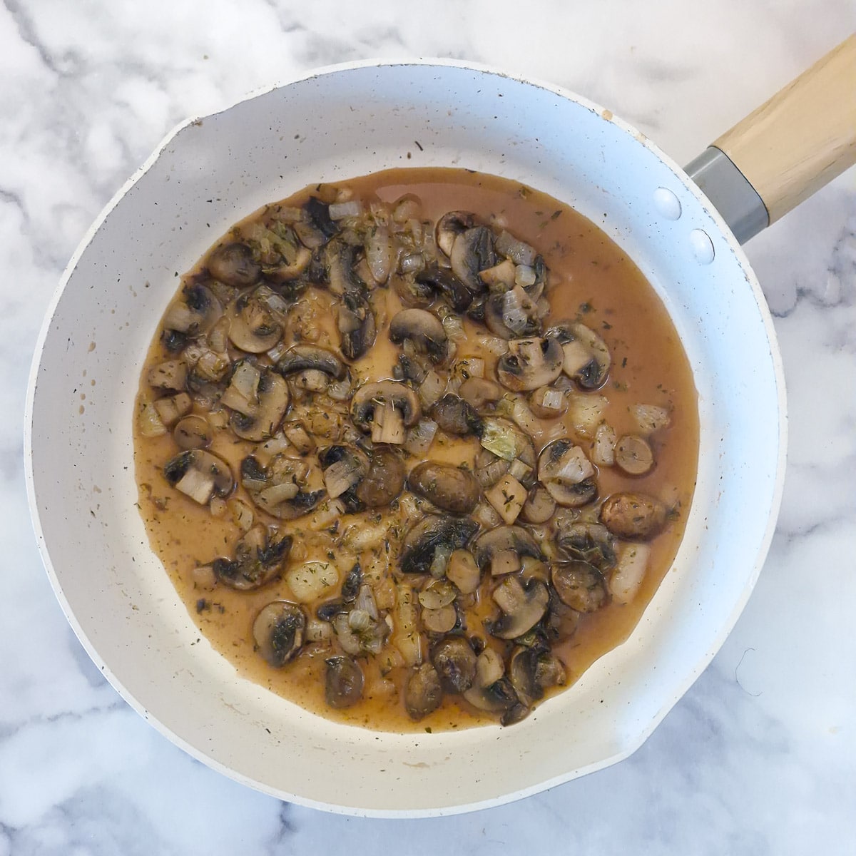 Step 3, masala wine poured into the pan with the mushrooms.