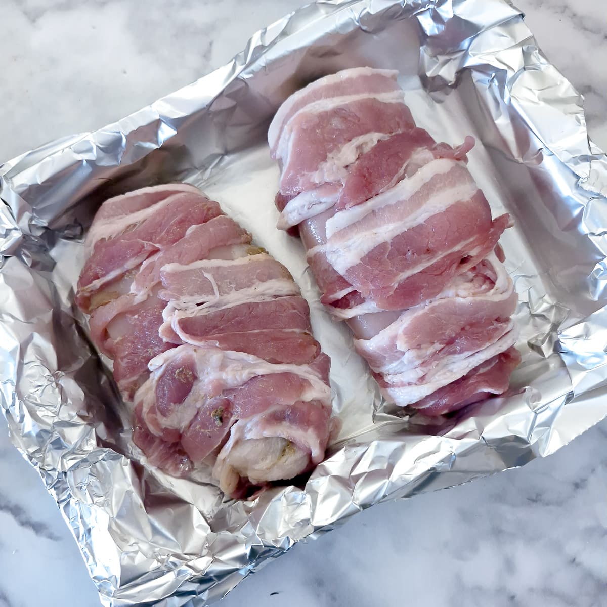 Step 8, 2 large bacon-wrapped chicken breasts in a foil-lined baking dish.