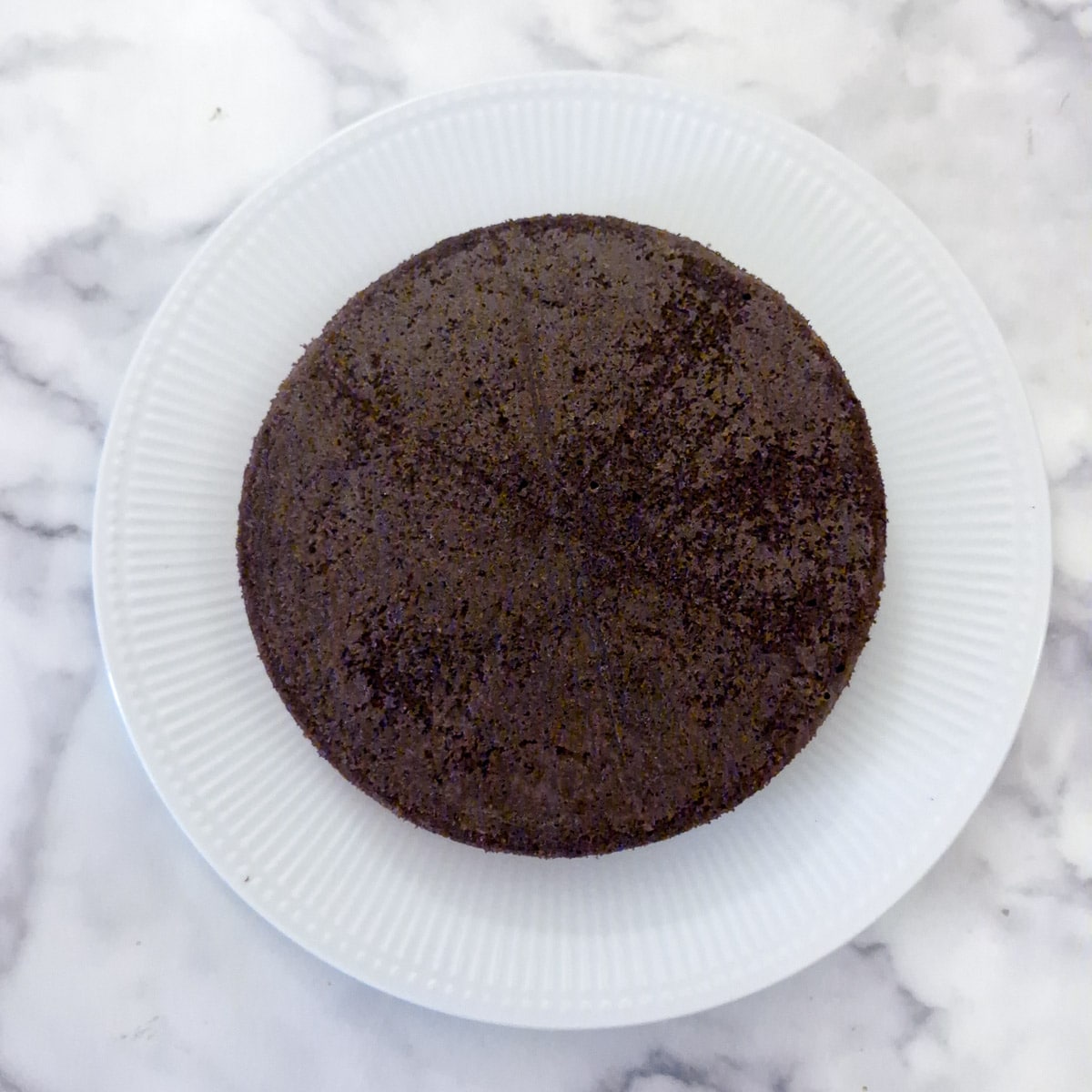 Step 12, One of the peppermint chocolate cake layers turned upside down on a plate.