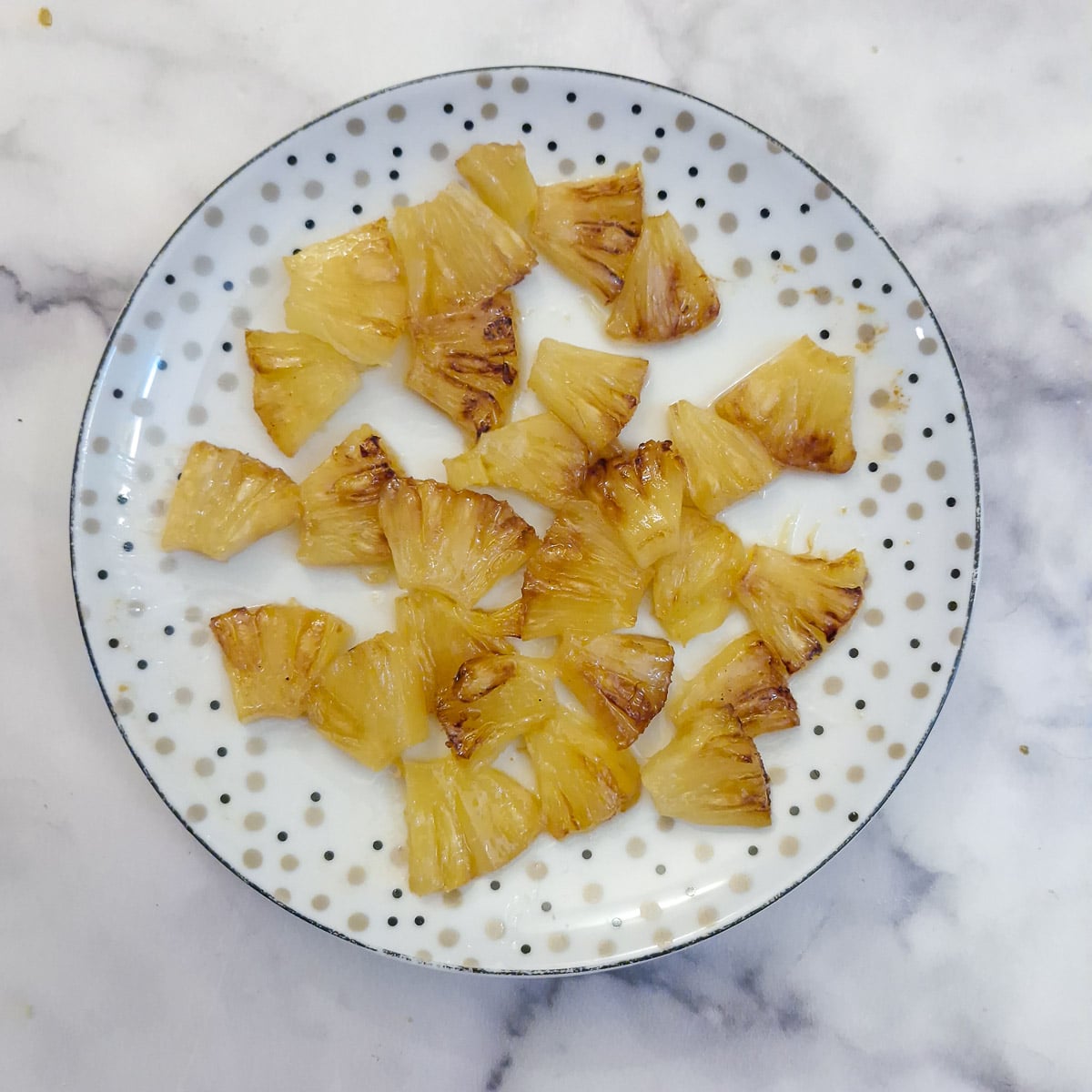 Pieces of chopped pineapple rings on a plate.