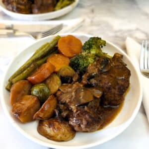 A plate of Salisbury stead with potatoes and vegetables.