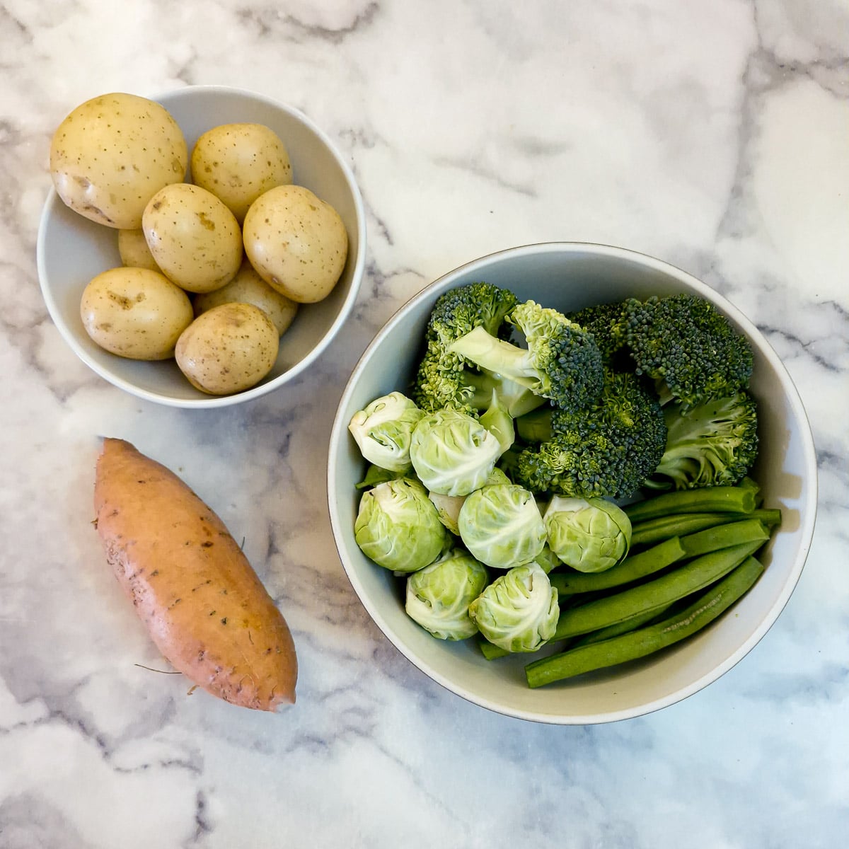 Dishes of raw potatoes and vegetables that were used in the recipe.