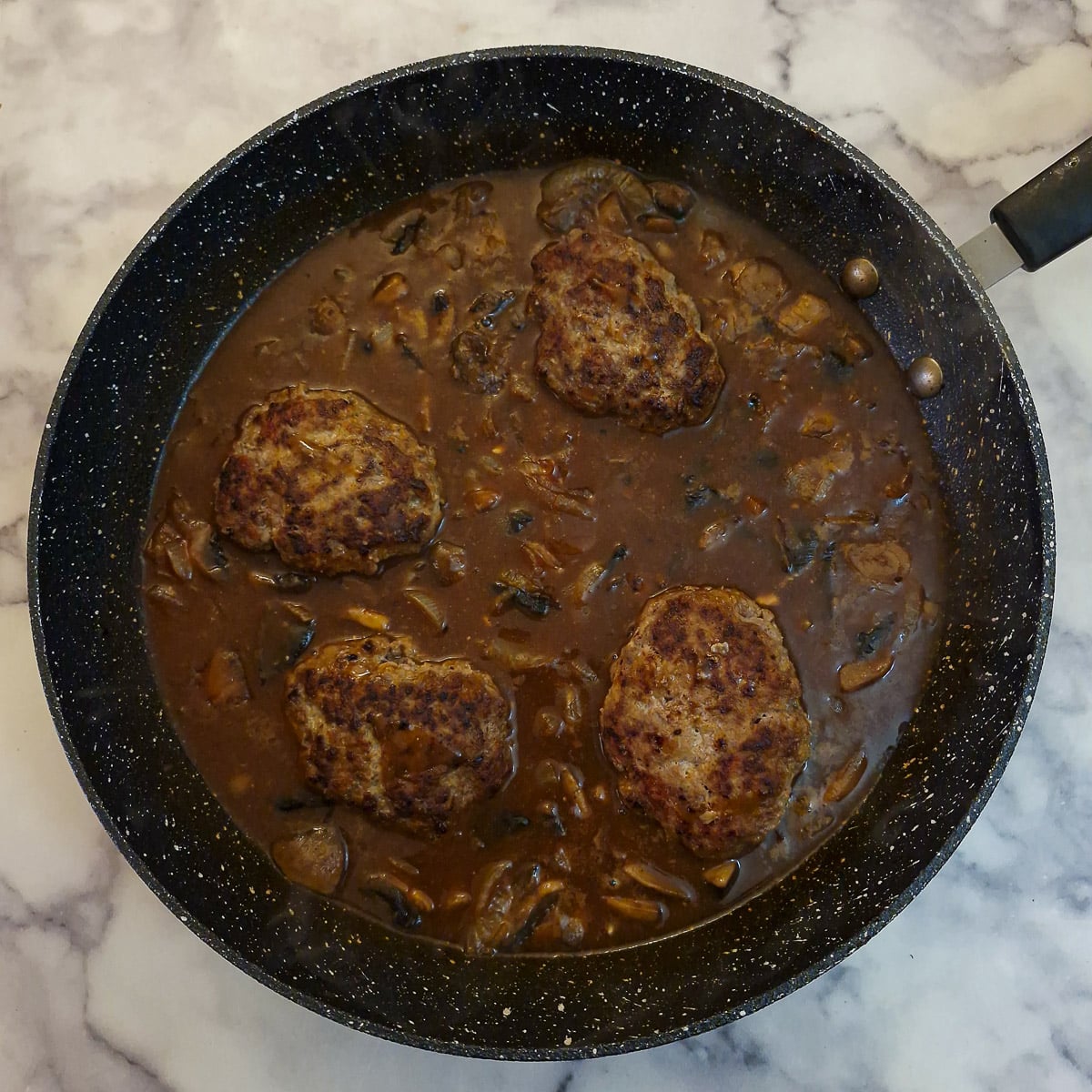 Step 11, 4 beef patties nestled in the mushroom and onion gravy.