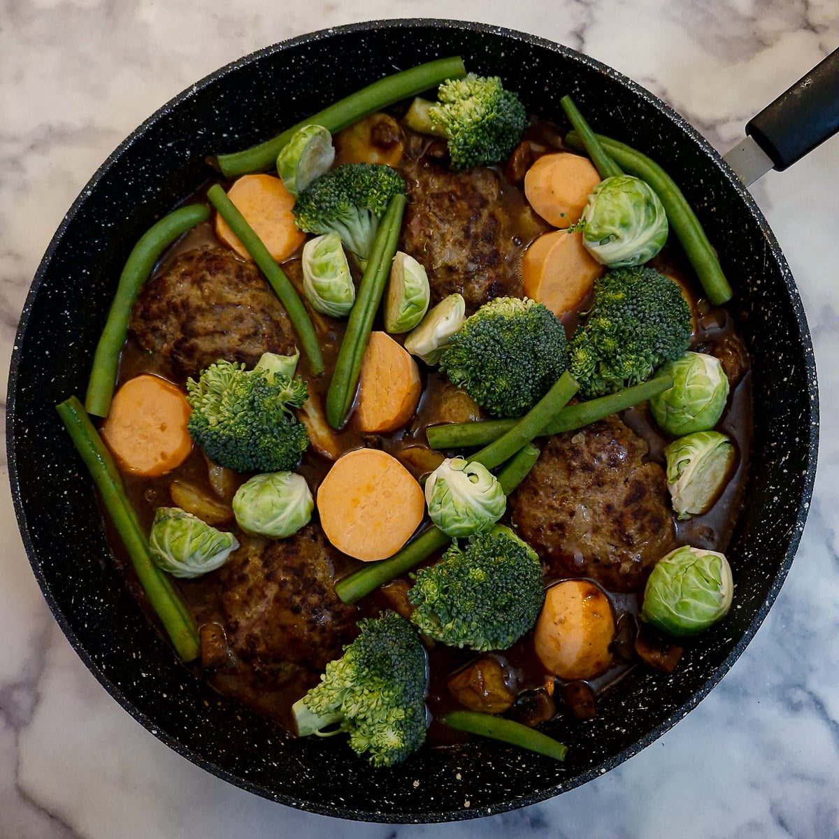 Step 12, vegetables arranged on top of the patties and gravy.